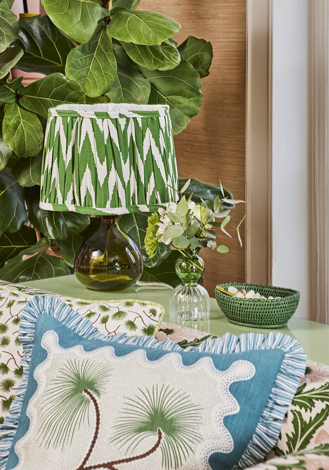 Green and white ikat-patterned lampshade with dark green glass base perfect for coastal cabana decor