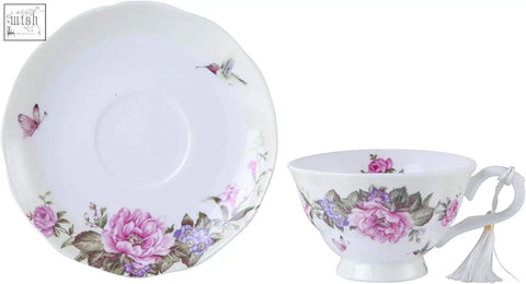 A delicate white porcelain coffee tea cup and saucer set with pink roses butterflies and hummingbird in a beautiful gift box