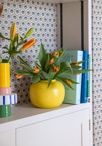 Bright yellow ceramic color blocking vase holding orange tulips perfect for home decor and floral arrangements