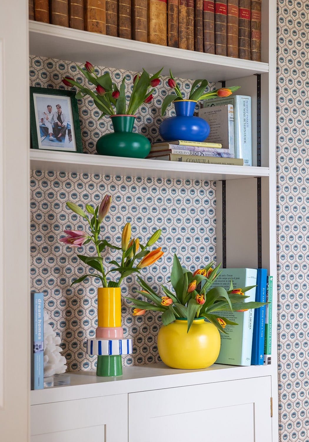 Vibrant yellow ceramic vase with color blocking holdin orange and pink tulips for a fresh decorative touch