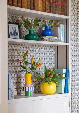 Vibrant yellow ceramic vase with color blocking holdin orange and pink tulips for a fresh decorative touch