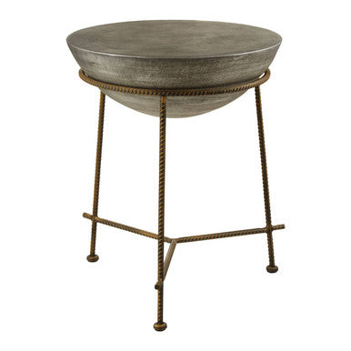 A concrete bowl shaped side table with a rustic hammered metal bronze finished stand and antique silver look