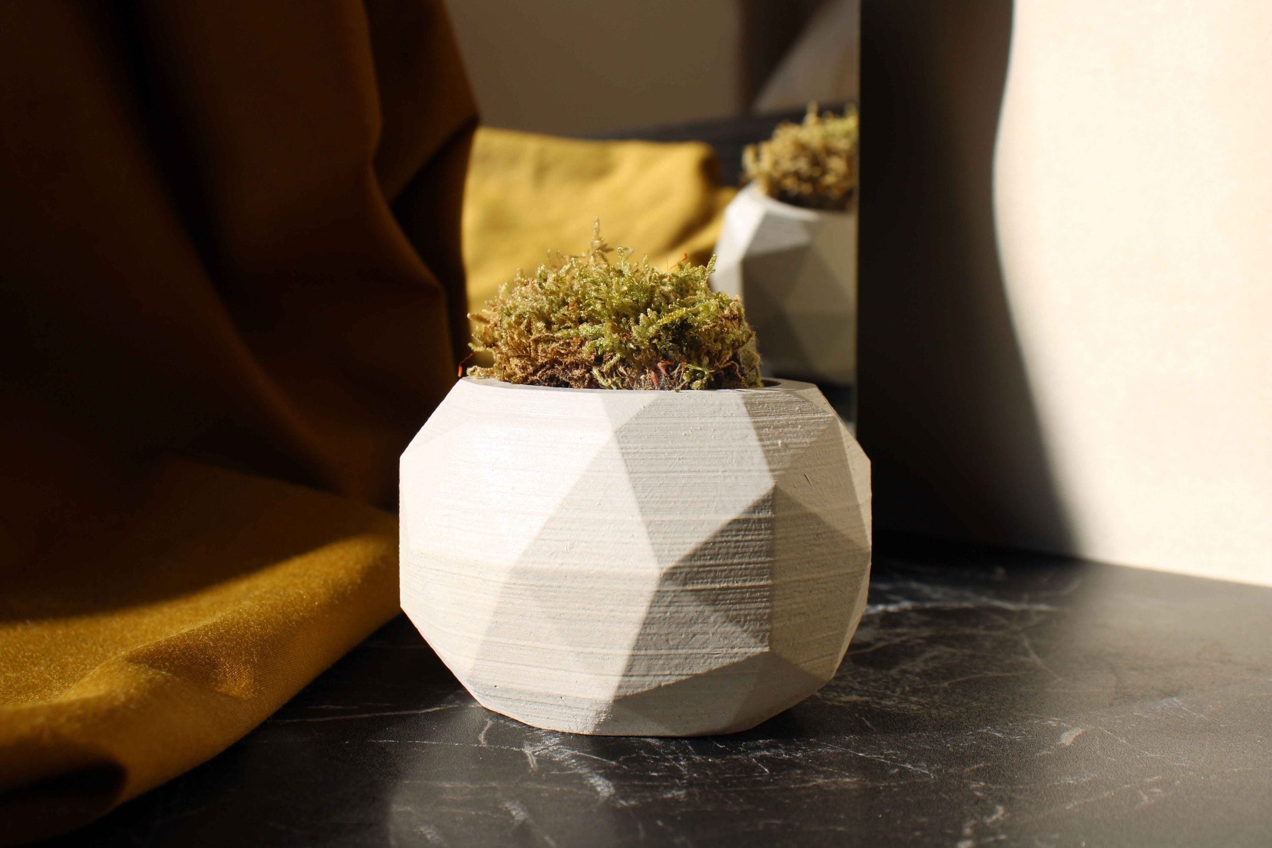 White concrete diagonal pot with matte finish and moss showcasing a high quality concrete diagonal planter