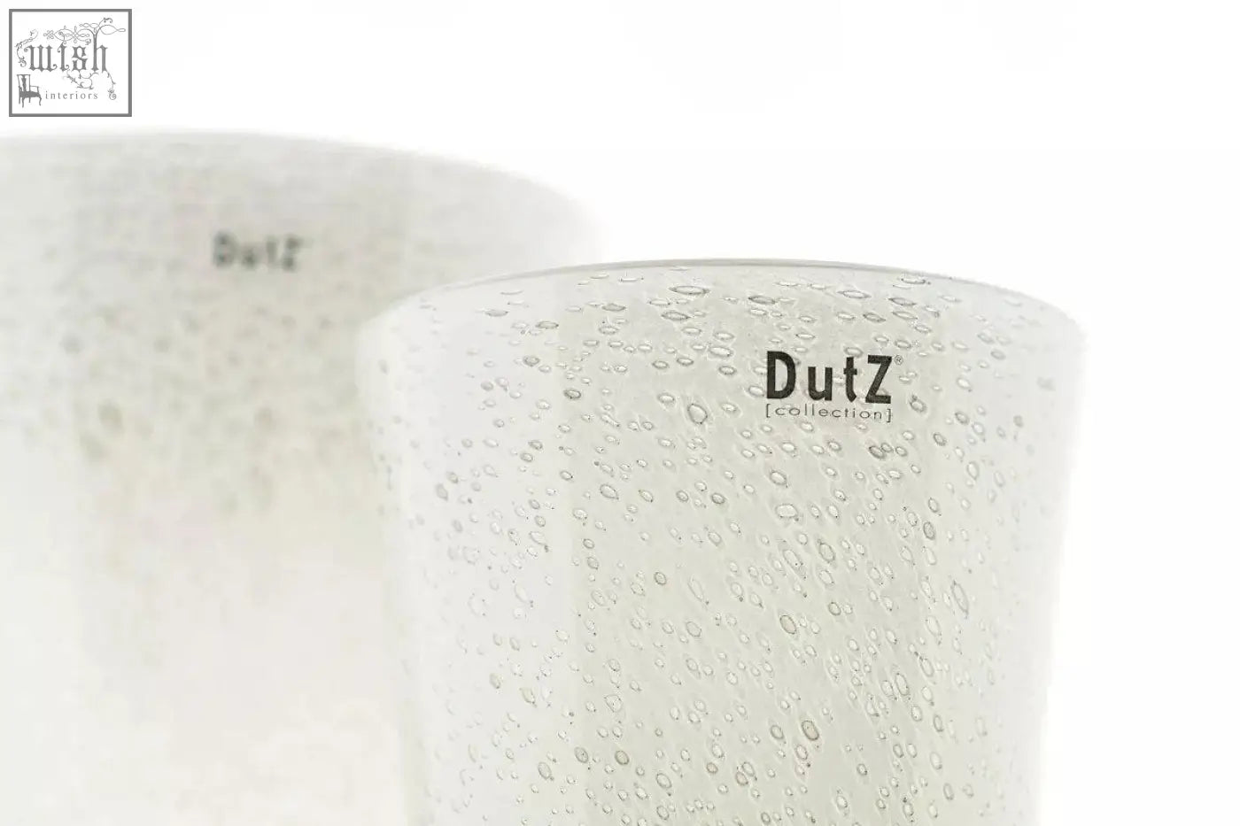 A frosted white mouth blown glass tumbler from dutz collection with a textured bubbly surface and dutz logo