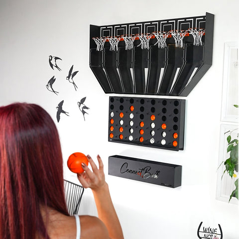 Black wall-mounted connect balls game with four balls and a central piece grid of orange and white balls below