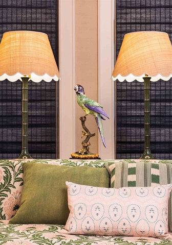 A vibrant intricately painted parrot figurine perched on a detailed bronze base called copacabana the hottest bird north of havana