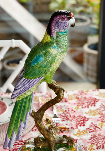 Vibrant green and purple parrot figurine perched on detailed bronze branch called copacabana the hottest bird north of havana