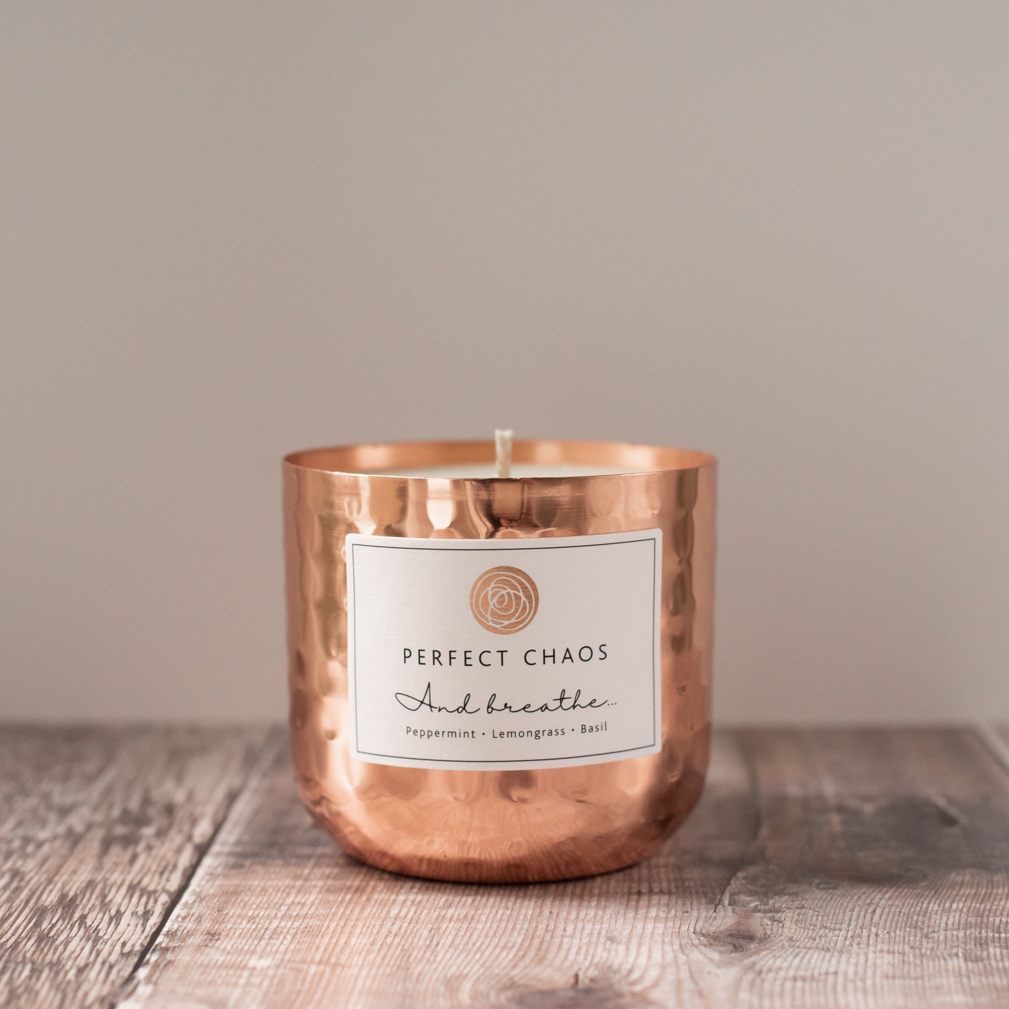 Copper dimpled candle jar with peppermint lemongrass basil scents and essential oils labeled perfect chaos