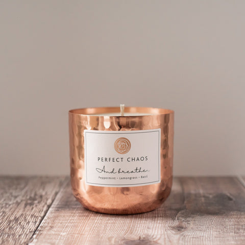 Copper dimpled candle jar with peppermint lemongrass basil scents and essential oils labeled perfect chaos