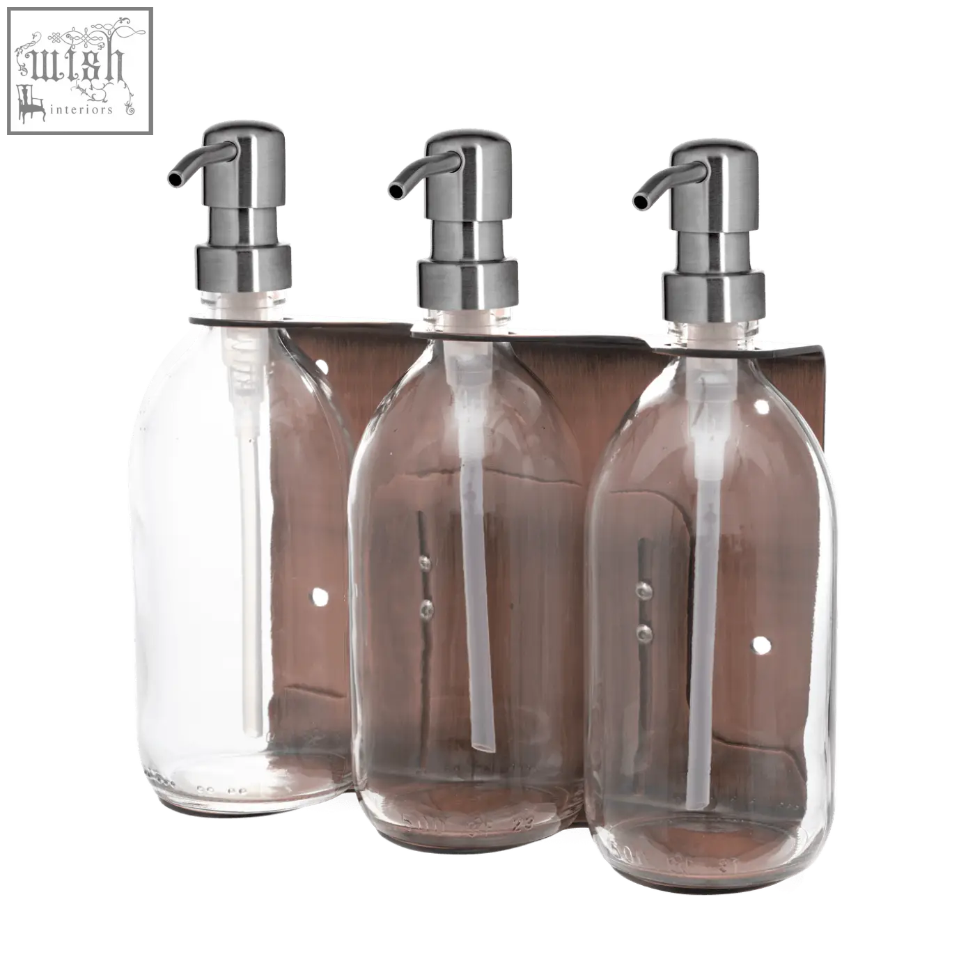Set of three clear glass soap dispensers with chrome pumps on a copper triple wall-mounted soap dispenser bracket