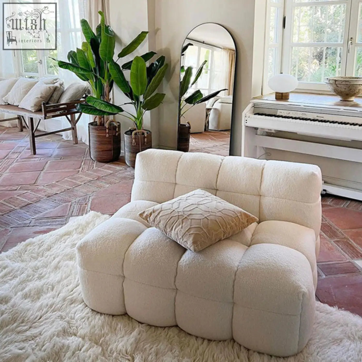 Cream-colored plush two seater sofa with quilted boucle fabric perfect for a cozy lazy seat