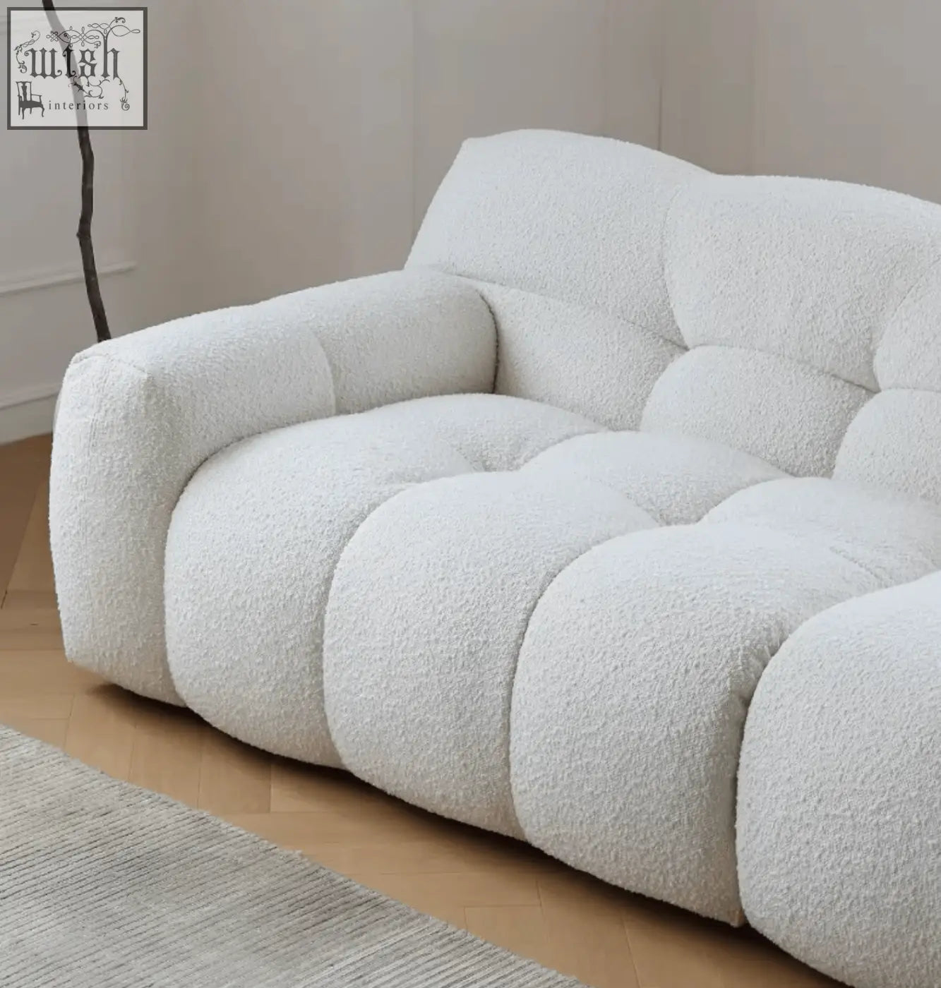 Cream-colored cora three seater sofa with plush tufted design and soft boucle fabric finish