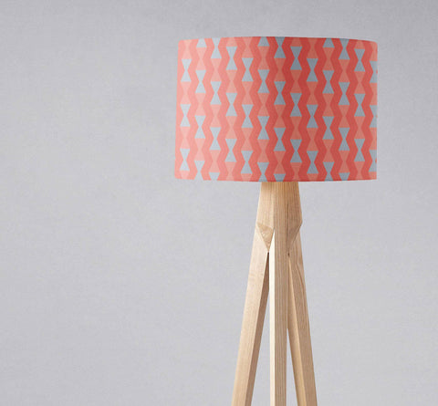 Coral and grey mid century modern table lamp with light blue geometric patterned lampshade on natural wood base with inch diameter
