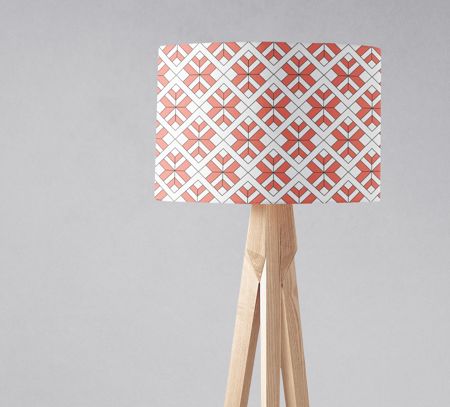 Coral and white geometric design lampshade with diamond pattern on light wood tripod base for table lamp use