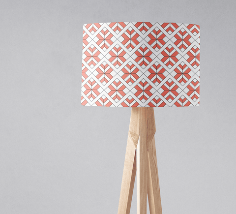 Coral and white geometric design lampshade with diamond pattern on light wood tripod base for table lamp use