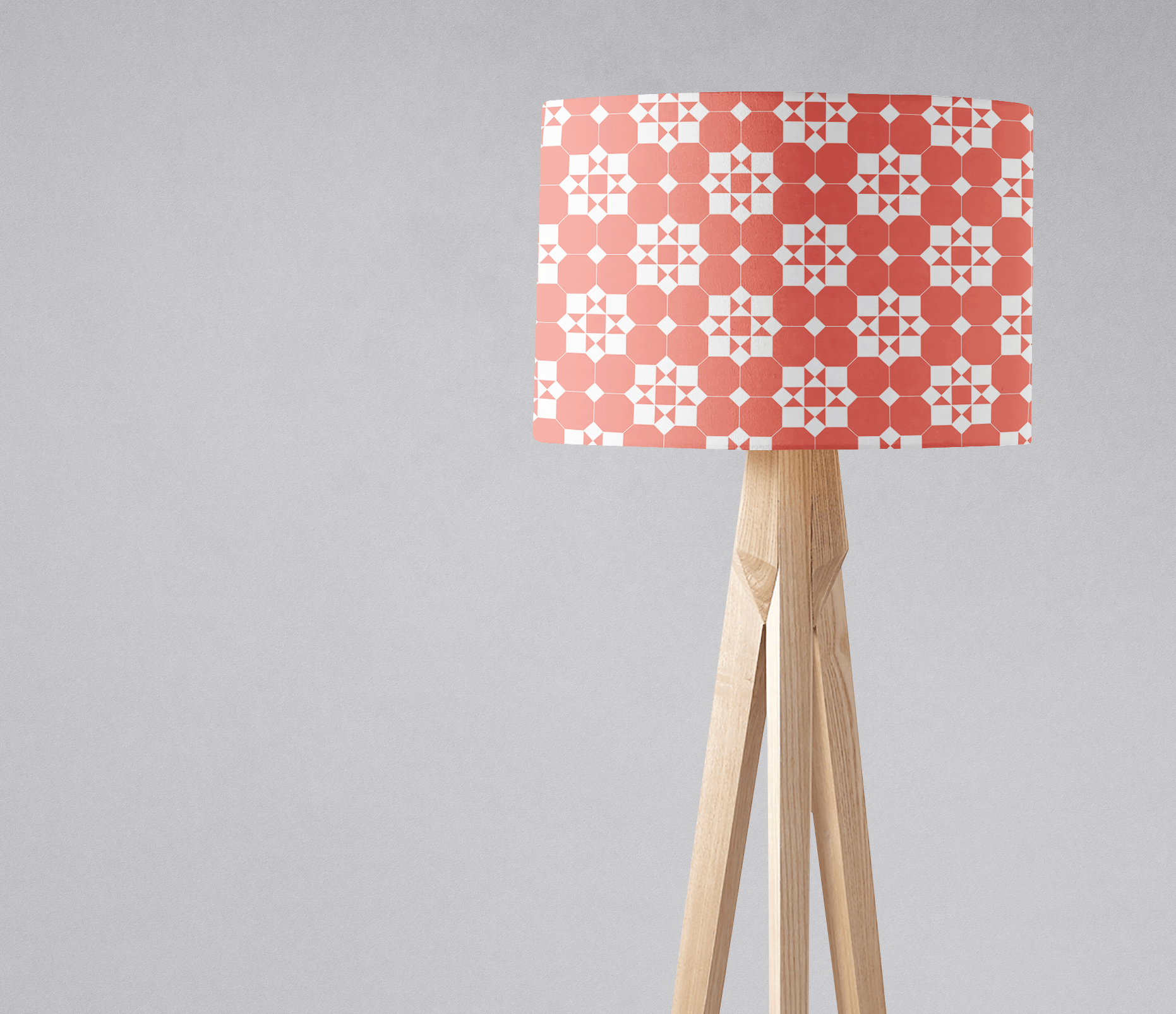 Coral and white geometric design lampshade on a light wood tripod base perfect for table lamp use