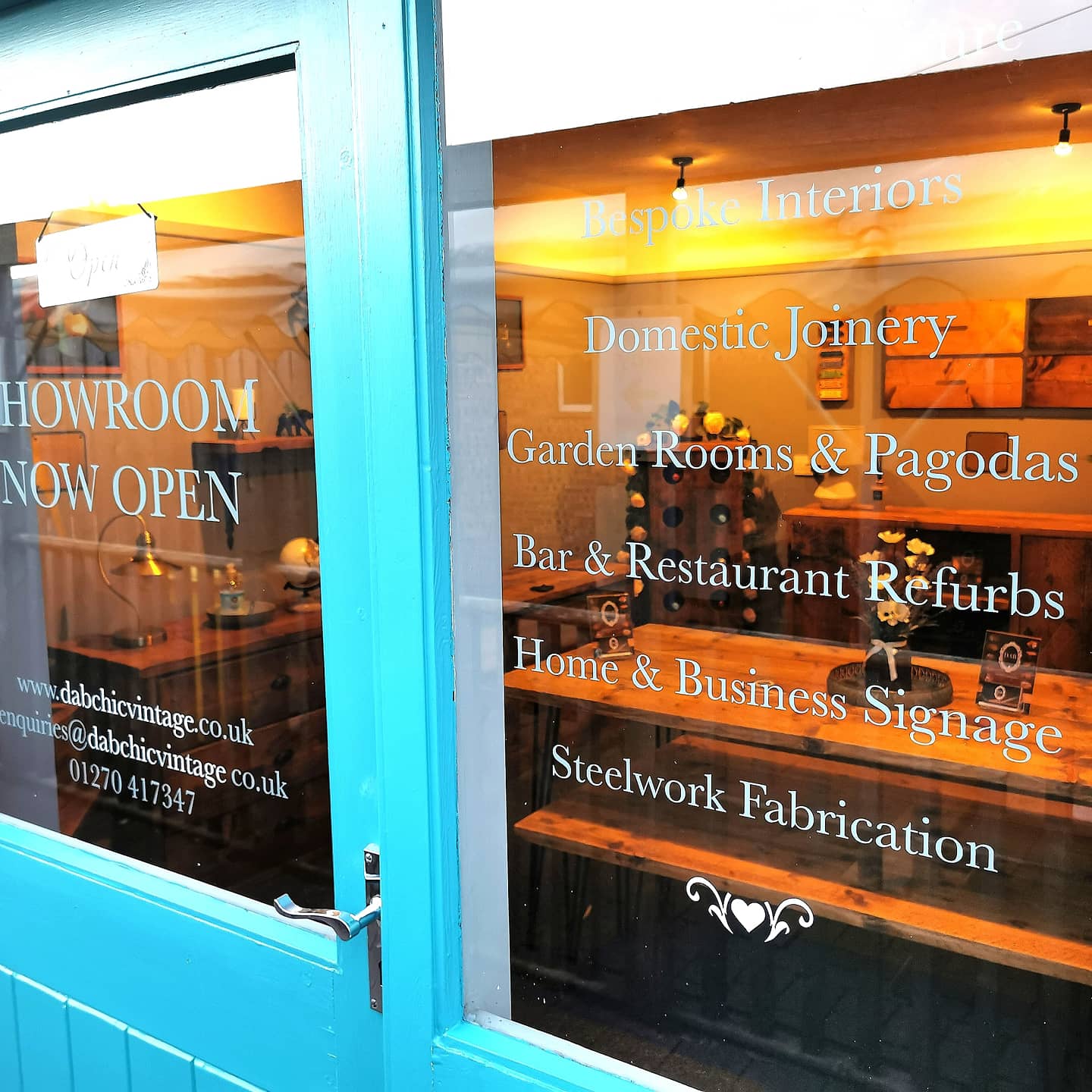 Storefront window showing wooden triangular wall shelves corner shelf with brackets and decorative joinery items