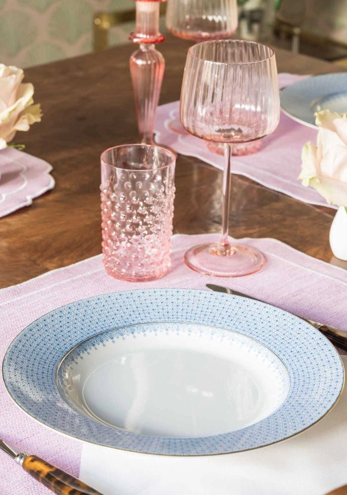 A delicate cornflower blue lace ceramic dinner plate with a dotted rim and smooth white center perfect for dining