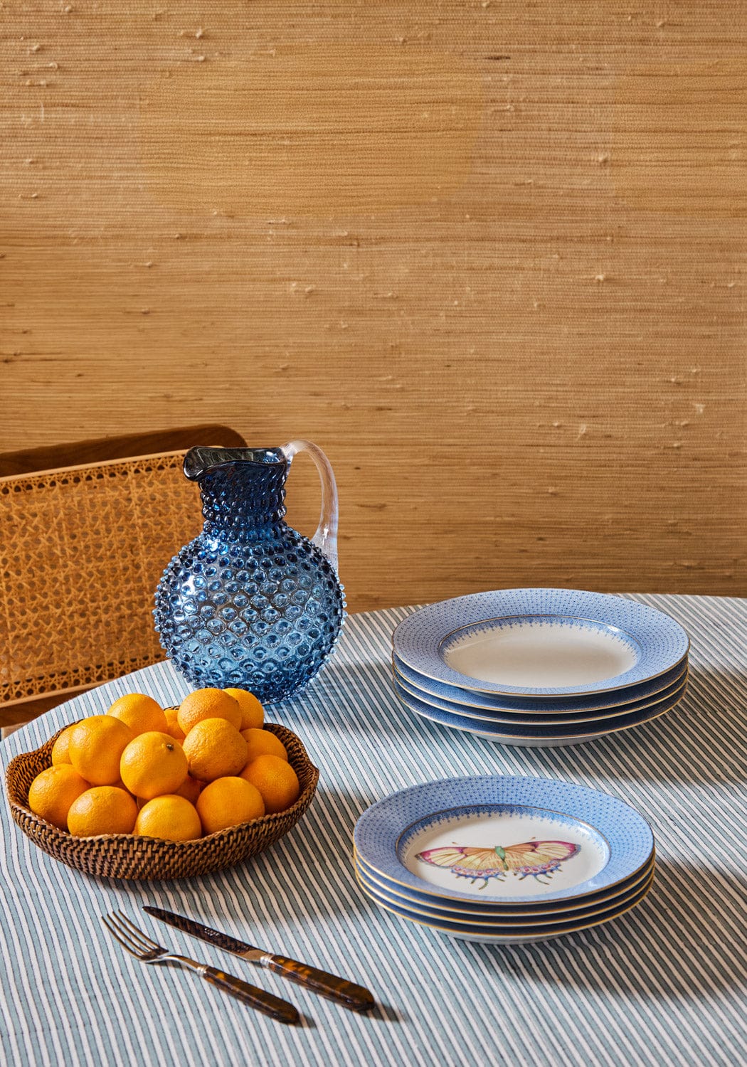 Stack of cornflower blue lace ceramic side plates with a delicate butterfly design on one blue lace plate pudding plate