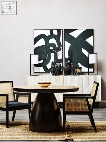 Dark wood pedestal dining table with round top paired with corso rattan chair featuring black frame and sleek design