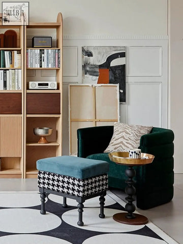 A plush teal velvet ottoman with a black and white houndstooth base paired with the cosmo round side table with gold tray and vintage charm