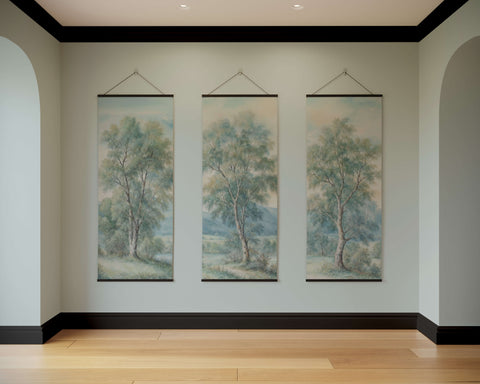 Three vertical canvas paintings in black frames showing green and blue trees as a countryside tapestry wall art