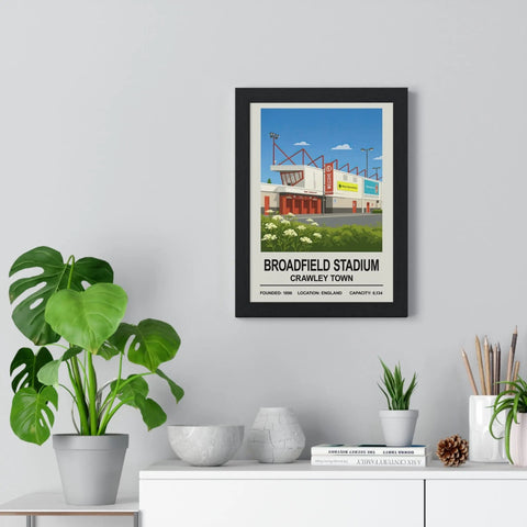 Black-framed vintage travel-style poster print of crawley broadfield stadium with bold white text on blue sky background