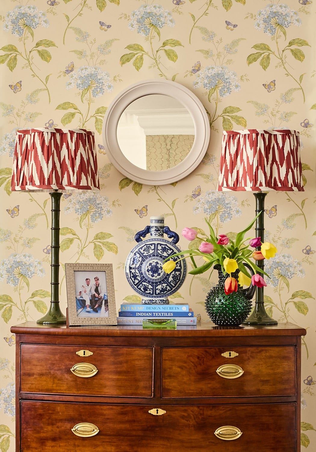 Cream and beige patterned photo frame 7x5 resting next to a blue and white ceramic vase on a wooden dresser