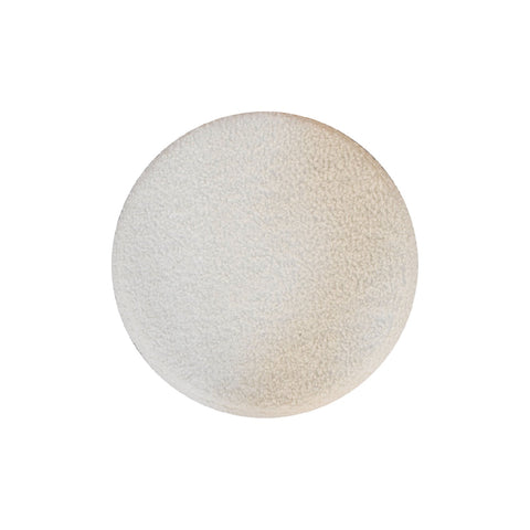 Cream boucle petite footstool with a round off-white textured fabric pad and an uneven surface for cozy seating