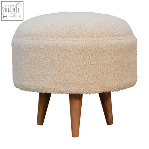 Cream boucle rounded footstool with cream sheepskin texture and solid mango wood tapered legs for comfy seating