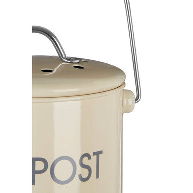 Cream compost bin made of metal with a handle and post lettering on the side for easy composting use