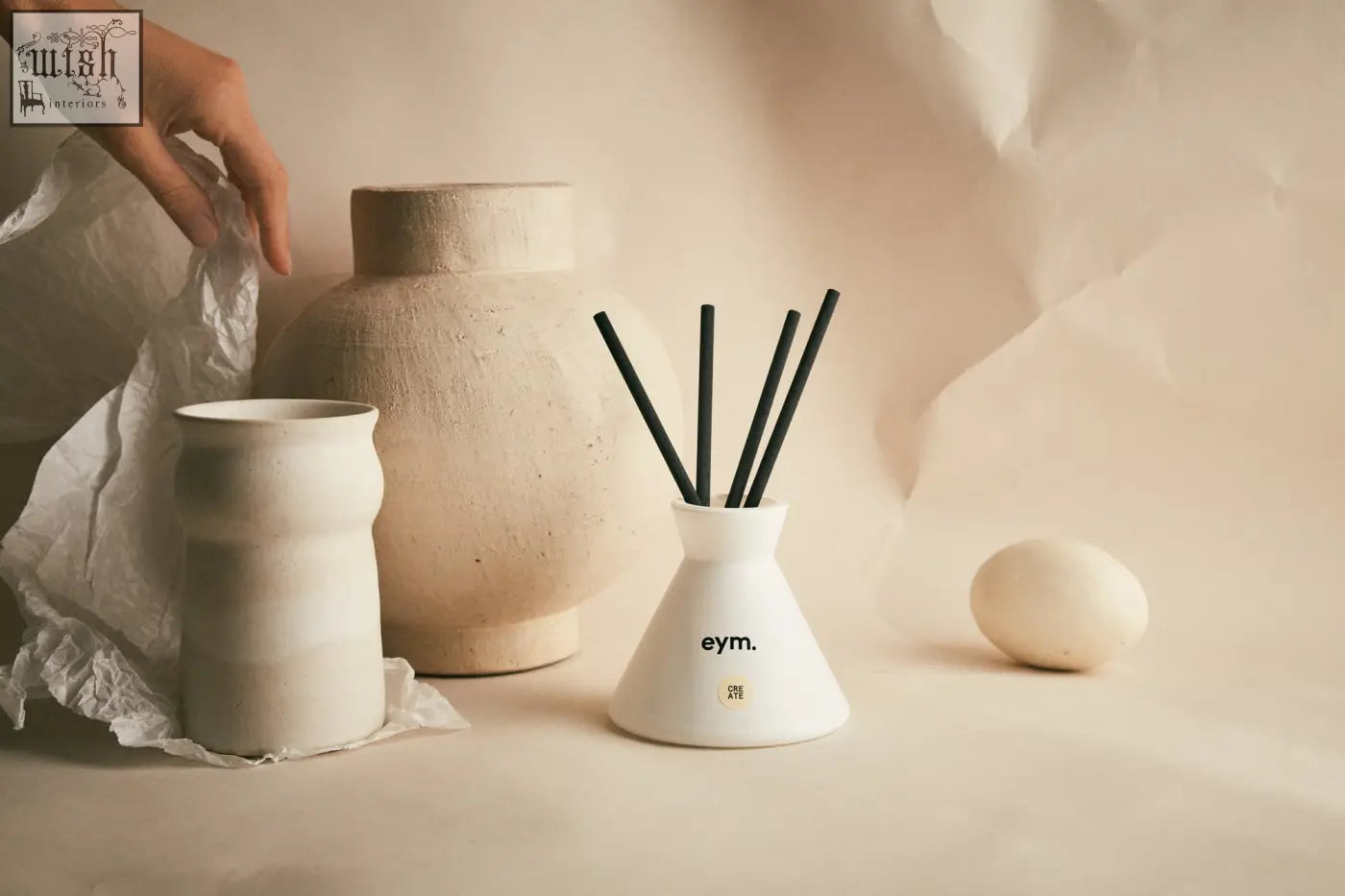 White ceramic diffuser with black reed sticks and eym branding for home fragrance in the create diffuser product line