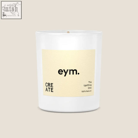 A minimalist white glass standard candle jar with a pale yellow label from eym designed for modern home decor