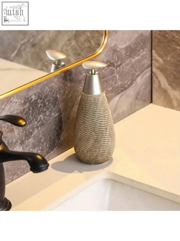 Silver-toned retro style hand soap dispenser with woven mesh body and sleek metallic pump for bathroom and kitchen use