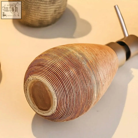 A terracotta ribbed ceramic retro style soap dispenser with a metallic pump for hand soap in bathrooms and kitchens