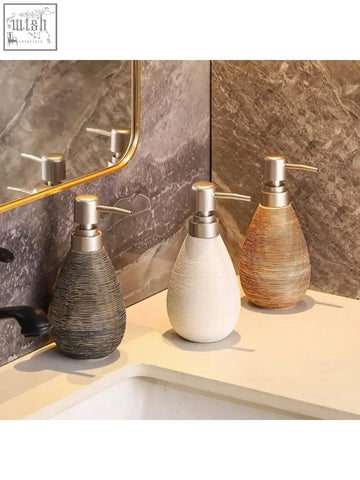 Three retro style ceramic soap dispensers in gray white and gold with metallic pumps for hand soap in bathrooms kitchens and toilets