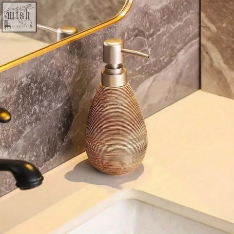 A sleek teardrop-shaped retro style soap dispenser with bronze woven ceramic body and metallic pump for hand soap use