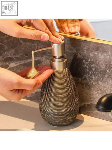 A sleek retro style ceramic soap dispenser with a brushed silver pump perfect for hand soap in bathrooms and kitchens