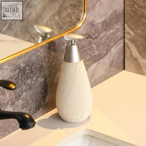 Cream-colored ceramic retro style soap dispenser with textured body and sleek silver pump for hand soap use