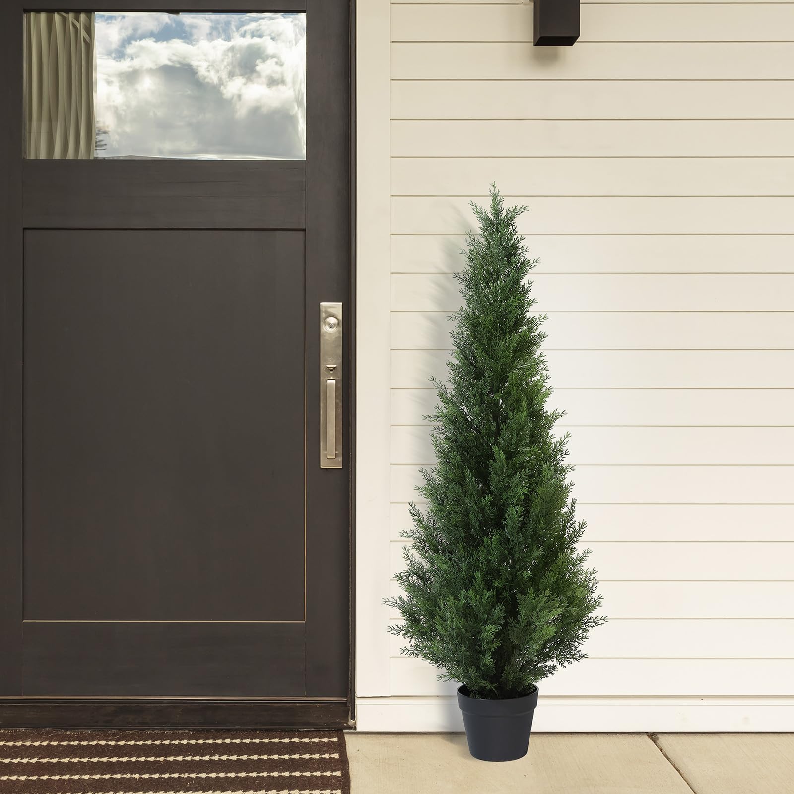 Dark green artificial cedar tree in a black plastic pot perfect for outdoor garden or porch decoration
