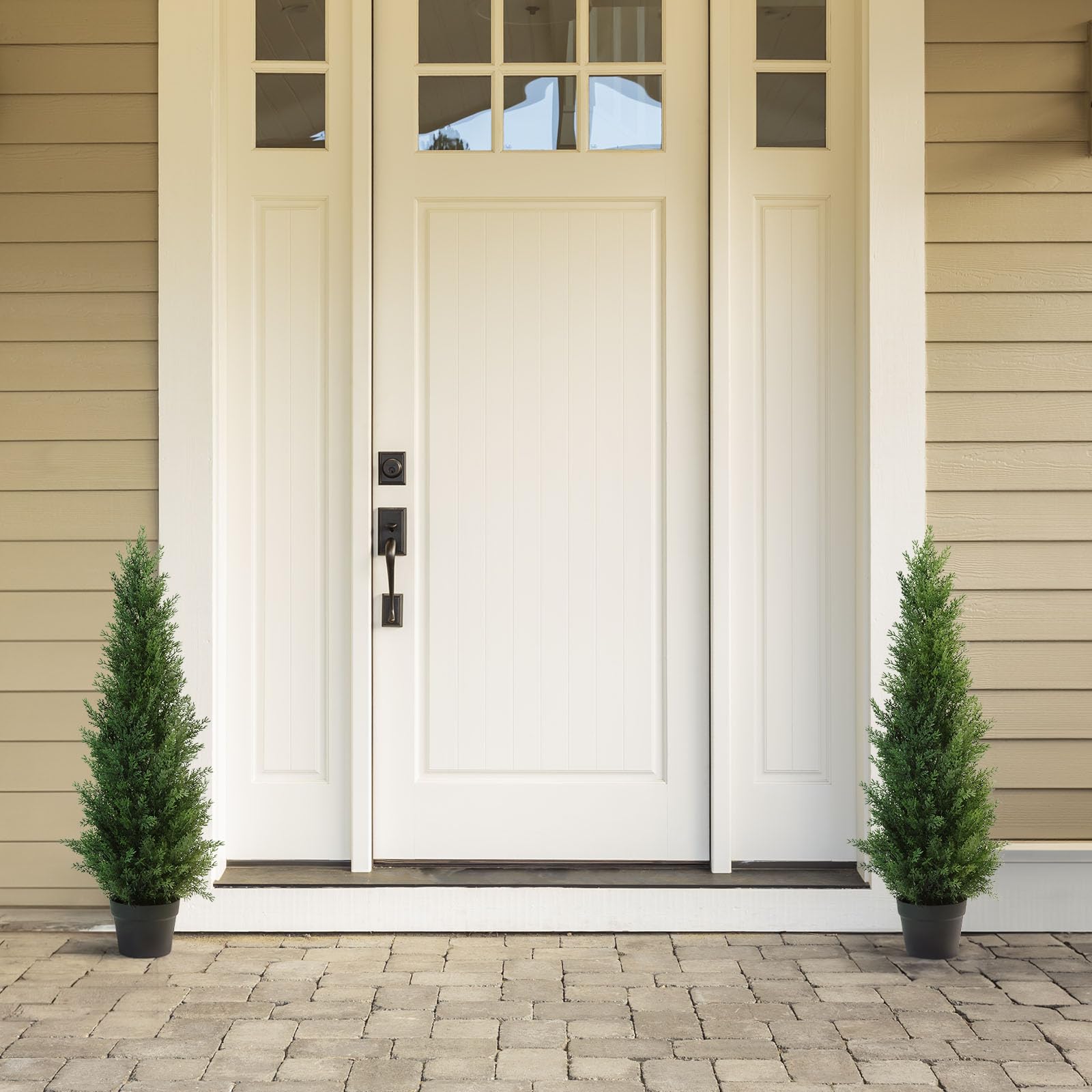 White front door with black hardware and glass panel featuring two 95 cm artificial cedar trees in plastic pots for porch decor