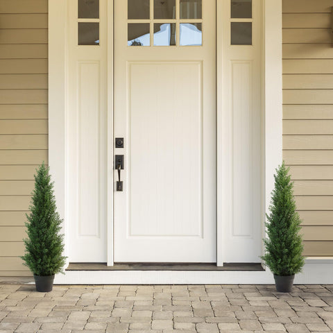 White front door with black hardware and glass panel featuring two 95 cm artificial cedar trees in plastic pots for porch decor
