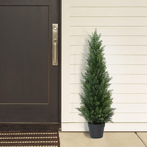 A tall artificial cedar tree in a sleek black pot perfect for outdoor garden or front porch decoration