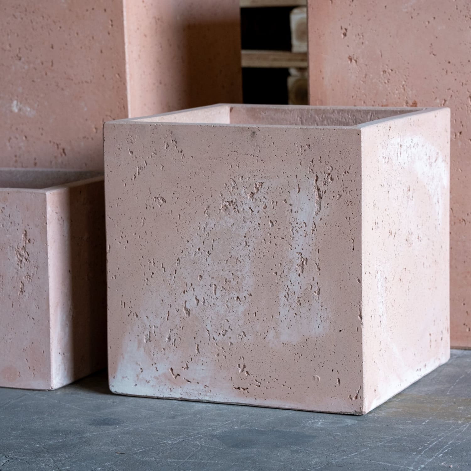 A matte-finished blushstone 20cm square concrete plant pot with textured surface perfect for compact greenery and garden tables