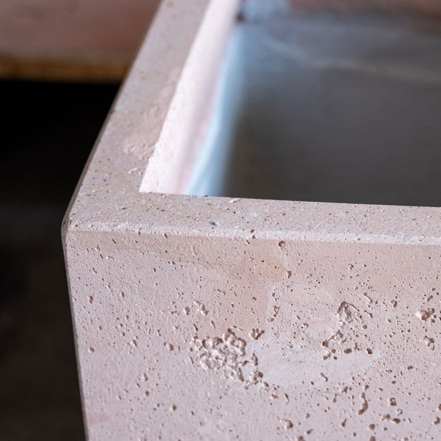 A blushstone light pink concrete planter with textured speckled surface and clean edges perfect for compact greenery on garden tables