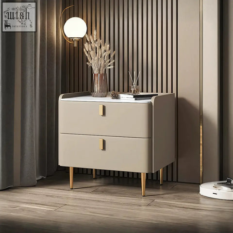Beige two-drawer cunha bedside table with gold-tone handles and legs in a sleek modern design