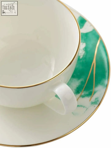 A premium porcelain white teacup and saucer set with gold banding and green floral patterns 200ml bone china