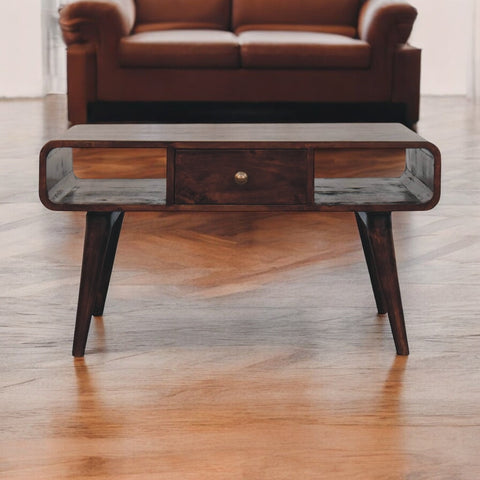 Curved california walnut coffee table with dark wood finish sleek edges and central drawer with brass knob made from solid mango wood