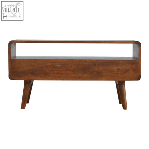 A sleek mid-century modern coffee table in curved chestnut finish with tapered legs and rich mango wood color