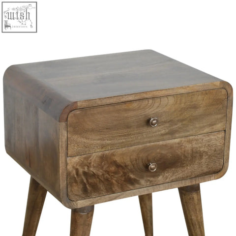 A rustic wooden bedside table with two drawers, rounded edges, tapered legs, and a grey washed finish